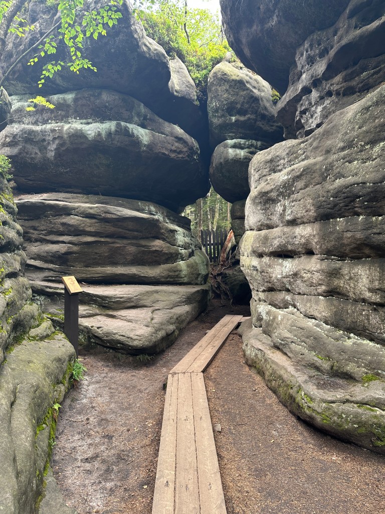 Formacje skalne składające się z poziomych warstw. Wysokie i sklepione na górze. Pomiędzy nimi ścieżka z drewnianych desek